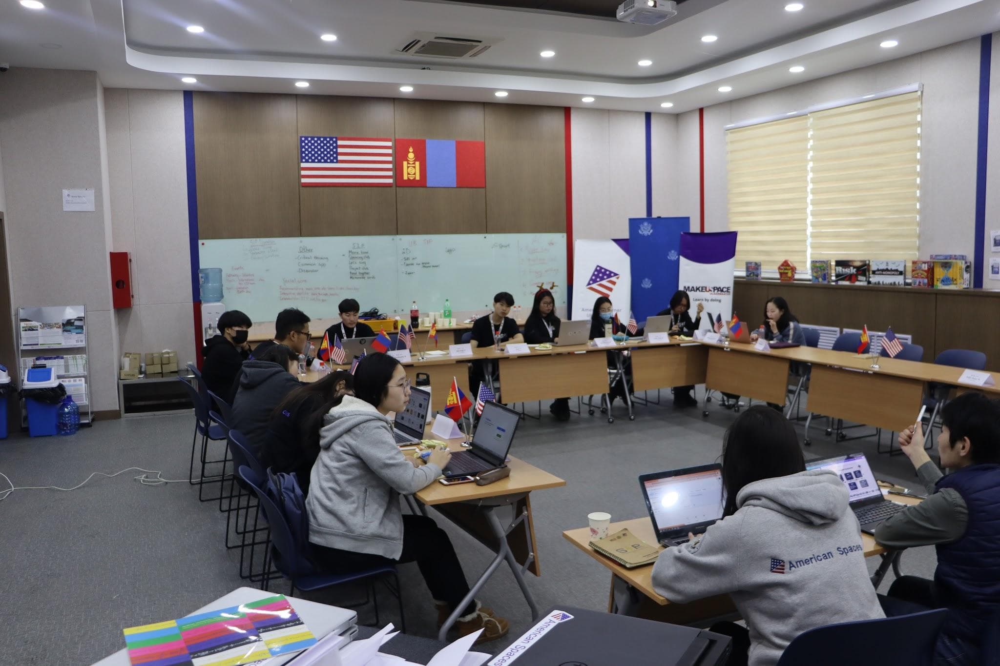 SIP interns in a planning session with U.S. and Mongolian flags